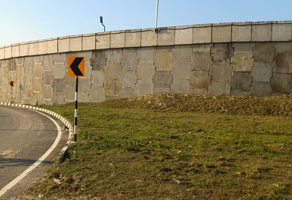 Roadside retaining wall and access road